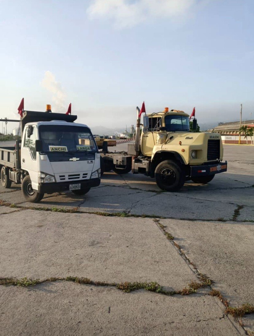 Camión volteo Chevrolet y chuto Mack en patio